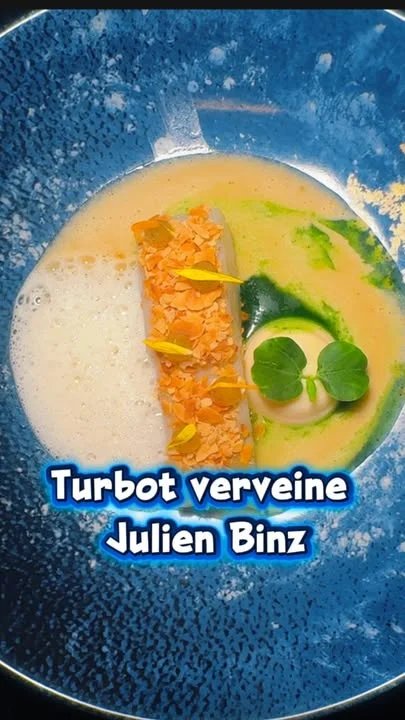 🌿 Le turbot confit à l’huile de verveine, amandes torréfiées et beurre blanc citronnelle-verveine de Julien Binz.
💛 À Ammerschwihr, c’est Barbara, cheffe de partie, qui réalise le dressage. Elle commence par une brunoise de céleri branche cru, travaillée en pickles à la verveine.
🌿 Le turbot est cuit à basse température, confit dans une huile de pépins de raisin infusée à la verveine, puis légèrement snacké. Barbara le recouvre d’une chapelure de panko enrichie d’amandes effilées torréfiées, qui apporte le croustillant.
🍋 Un gel verveine-citron apporte acidité et fraîcheur. Une purée céleri-amande développe l’onctuosité et la rondeur, accompagnée d’une essence de verveine aux notes florales concentrées.
🌺Quelques fleurs et pétales d’hibiscus, un nuage de lait d’amande à la verveine, puis un beurre blanc citronnelle-verveine viennent réunir l’ensemble.
💙 Posé dans une assiette bleu marine, comme replongé dans son élément, le turbot s’inscrit dans une composition tout en fraîcheur, finesse et équilibre.

🌟 🌿À découvrir au Restaurant Julien Binz à Ammerschwihr.
🌿👉 Lien de réservation en story.

🖊️📸 Sandrine Kauffer
