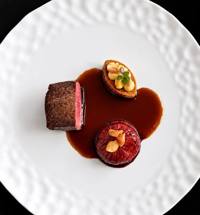 🍂 Le chevreuil de Julien Binz en 2 actes

✨ Deux interprétations d’un même gibier, deux expressions de la cuisine du chef étoilé Julien Binz.

🍁 Une rencontre entre la profondeur d’un civet traditionnel et l’élégance d’un filet rôti, sublimée par la figue violette, le panais et la cacahuète.

🦌 Premier acte : le civet, hommage à la tradition.
🔥 Une épaule de chevreuil français, issue de la chasse, braisée toute une nuit à basse température, jusqu’à devenir incroyablement fondante.

🍷 Délicatement effilochée, elle s’enrobe d’une sauce civet intense, réalisée à partir de son jus de cuisson, longuement réduit et lié au pain brûlé.

🌿 La touche finale ? Quelques gouttes de Chartreuse, qui apportent une fraîcheur végétale et réveillent les saveurs profondes du gibier.

🦌 Deuxième acte : le filet rôti, tout en finesse.
✨ Une chair tendre et délicate, accompagnée d’une sauce aux baies de genièvre, inspirée de la grande tradition des sauces Grand Veneur.

🍇 Vin rouge, vinaigre de Xérès, myrtilles, poivre noir et genièvre composent une sauce brillante, puissante et subtilement fruitée.

💜 À ses côtés, une figue violette pochée au porto et aux épices douces, puis délicatement glacée dans son jus sirupeux. Un condiment de figue au citron confit vient apporter cette pointe d’acidité qui change tout.

🥜 Le détail gourmand : un millefeuille croustillant de panais et de cacahuète. Sablé croquant, mousseline soyeuse, cacahuètes grillées et salées…

💫 Une alliance surprenante entre douceur, rondeur et gourmandise.

❤️ Deux préparations, deux émotions qui font dialoguer tradition et créativité.

📞 Réservations : 03 89 47 16 05 – Lien en story

✍️📸 Sandrine Kauffer 

#JulienBinz #Chevreuil